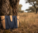 Portuguese cork bag by Zolla resting against a cork oak tree in a Portuguese forest, symbolising the journey from forest to fashion.